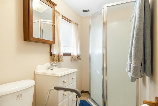 bathroom with toilet, a stall shower, and vanity