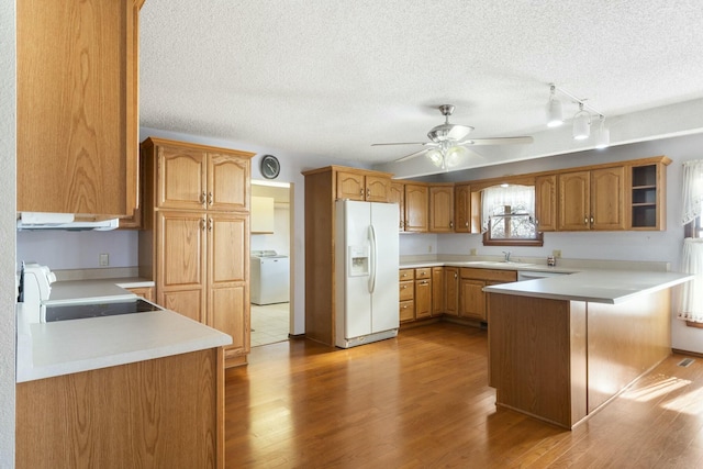 kitchen featuring light wood-style flooring, electric stove, washer / clothes dryer, white fridge with ice dispenser, and light countertops