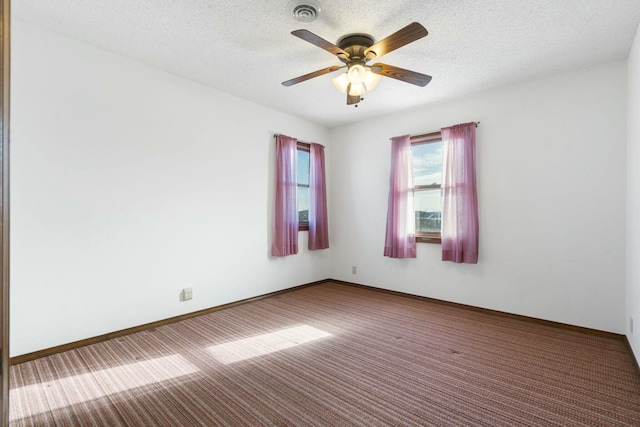 empty room with visible vents, a textured ceiling, ceiling fan, and carpet flooring