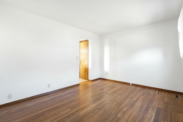 empty room featuring baseboards and wood finished floors