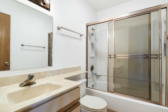 bathroom featuring vanity, toilet, and bath / shower combo with glass door