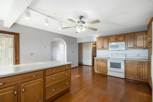 kitchen featuring white appliances, dark wood finished floors, light countertops, a textured ceiling, and brown cabinets