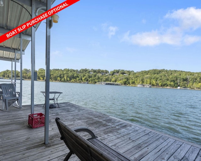 view of dock featuring a forest view and a water view