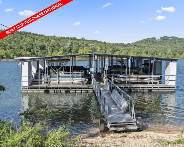 view of dock with a forest view, a water view, and boat lift