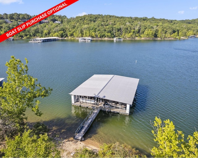 view of dock featuring a wooded view and a water view