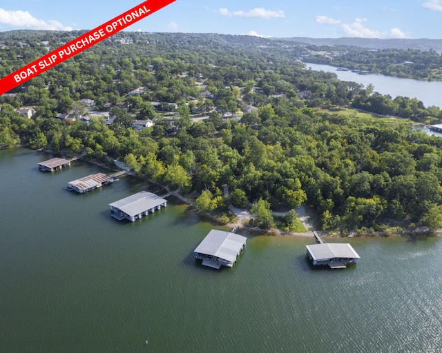 birds eye view of property with a wooded view and a water view