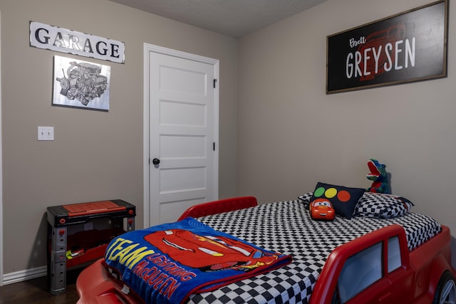 bedroom with a textured ceiling and hardwood / wood-style flooring