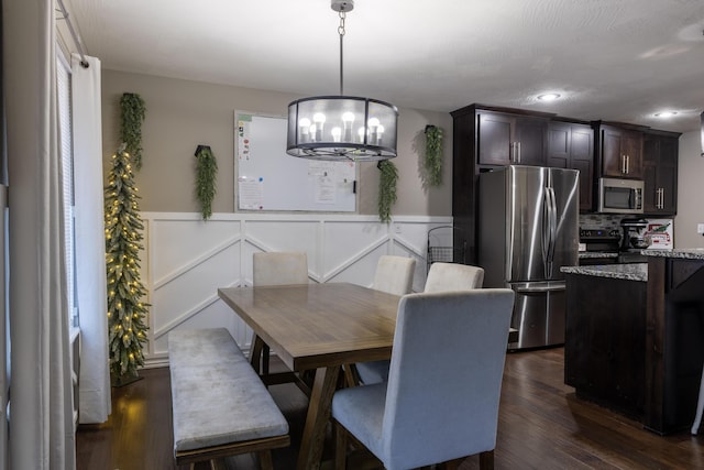 dining area featuring dark hardwood / wood-style flooring and an inviting chandelier