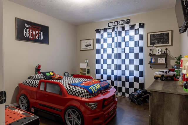 bedroom featuring dark hardwood / wood-style flooring and a textured ceiling