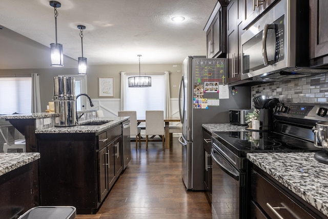 kitchen featuring decorative light fixtures, stainless steel appliances, dark wood-type flooring, and sink