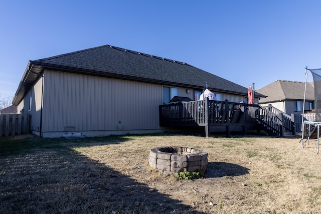 back of house with a yard, an outdoor fire pit, and a wooden deck