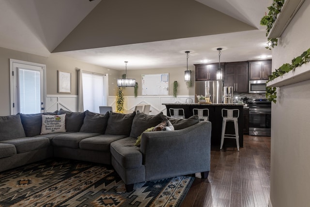 living room with dark hardwood / wood-style flooring and vaulted ceiling