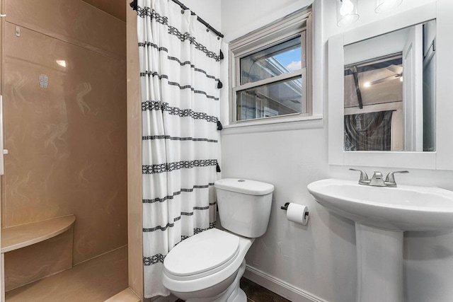 bathroom with toilet, walk in shower, and sink