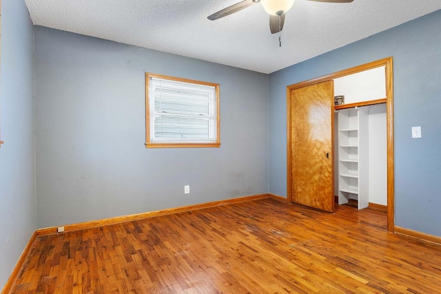 unfurnished bedroom with a textured ceiling, hardwood / wood-style flooring, and ceiling fan