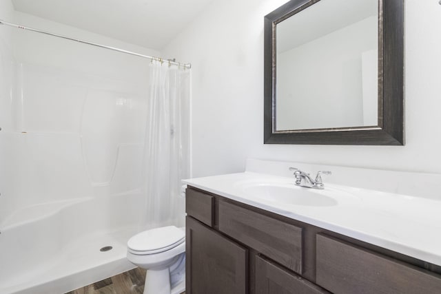 bathroom with hardwood / wood-style flooring, vanity, toilet, and walk in shower