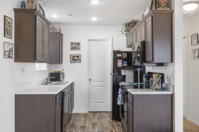 kitchen featuring dark brown cabinetry, range with electric cooktop, sink, and dark hardwood / wood-style floors