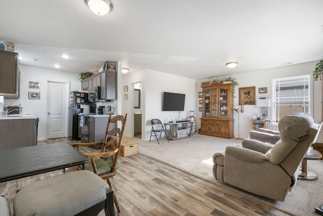 living room with sink and light wood-type flooring