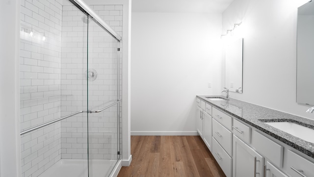 bathroom with vanity, hardwood / wood-style flooring, and a shower with shower door