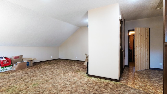 additional living space featuring a textured ceiling, carpet floors, and lofted ceiling