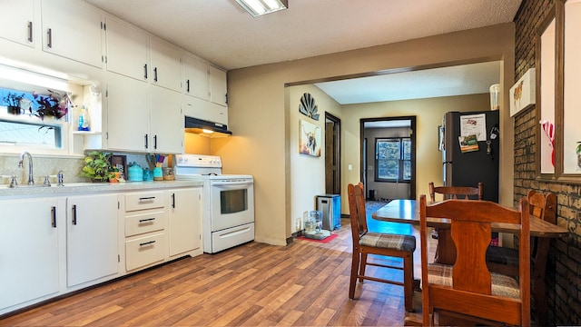 kitchen featuring stainless steel refrigerator, white cabinetry, white range with electric cooktop, extractor fan, and light wood-type flooring