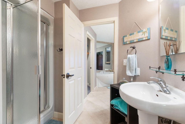 bathroom with plus walk in shower, tile patterned floors, and sink