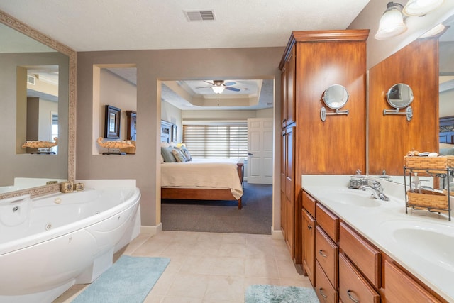 bathroom featuring a washtub, vanity, a tray ceiling, ceiling fan, and tile patterned flooring