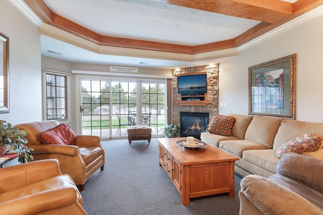 carpeted living room with a textured ceiling, a raised ceiling, ornamental molding, and a fireplace