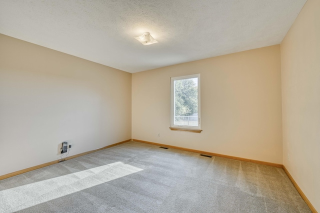 carpeted spare room featuring a textured ceiling