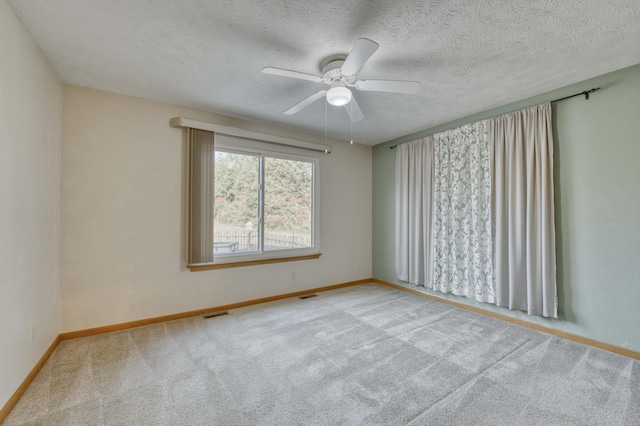 carpeted empty room with a textured ceiling and ceiling fan