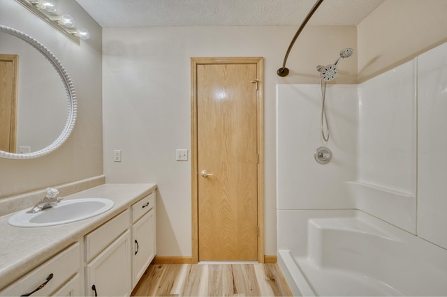 bathroom with a shower, wood-type flooring, and a textured ceiling