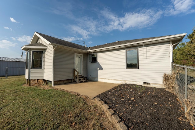 rear view of property featuring a lawn