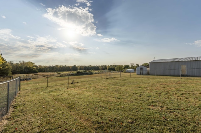 view of yard with a rural view and an outdoor structure