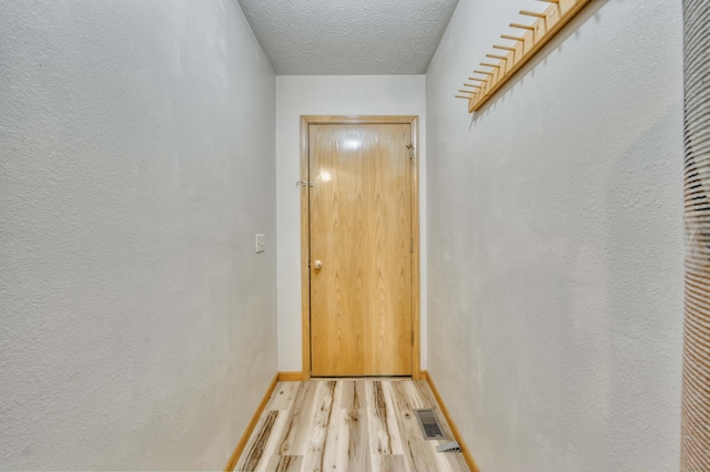 entryway featuring light hardwood / wood-style flooring and a textured ceiling