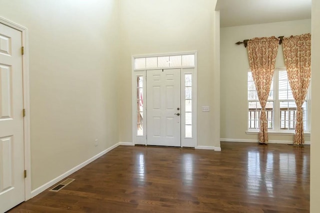 entrance foyer with dark hardwood / wood-style flooring and a healthy amount of sunlight