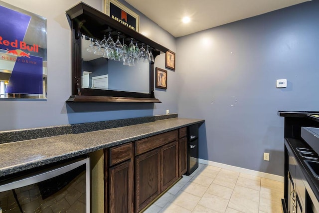 bar with dark brown cabinetry and wine cooler