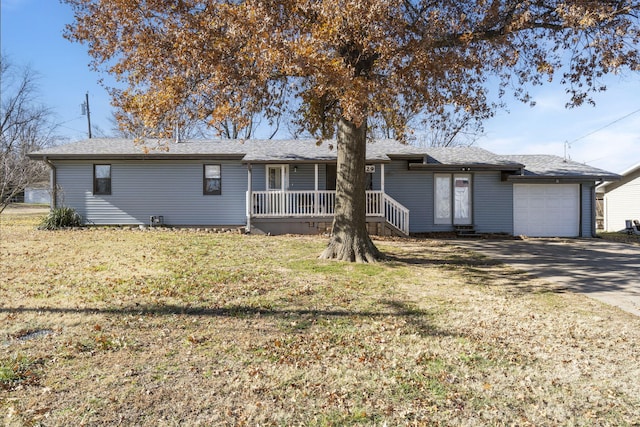 view of front of property featuring a front lawn, covered porch, and a garage