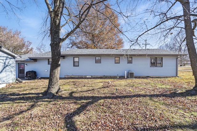 back of house featuring a lawn and central air condition unit