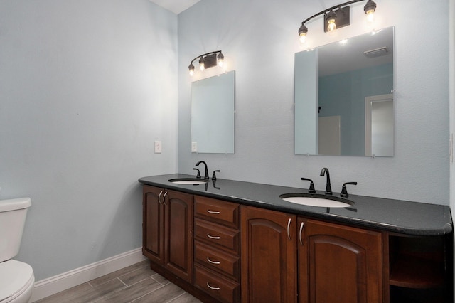 bathroom featuring hardwood / wood-style floors, vanity, and toilet