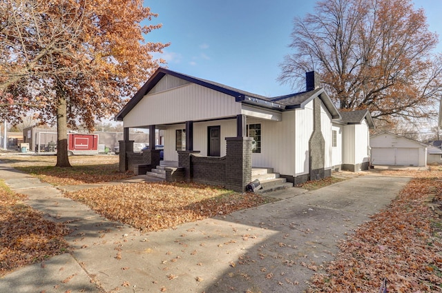 view of front of property featuring covered porch, an outdoor structure, and a garage