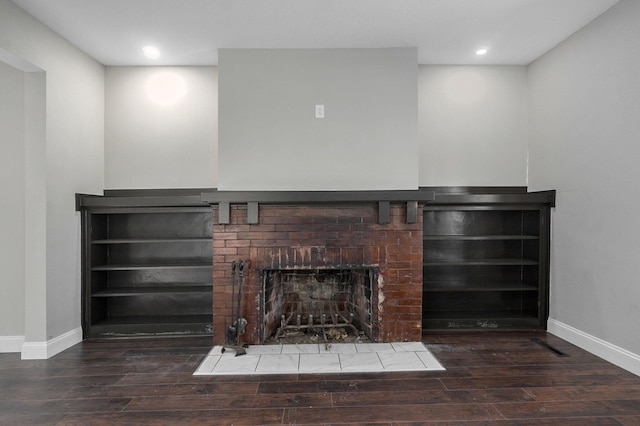 interior details with wood-type flooring and a brick fireplace