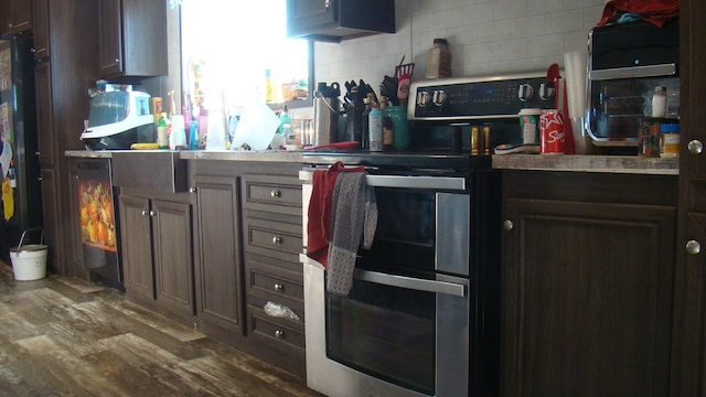 kitchen with tasteful backsplash, dark brown cabinetry, double oven range, and dark hardwood / wood-style flooring