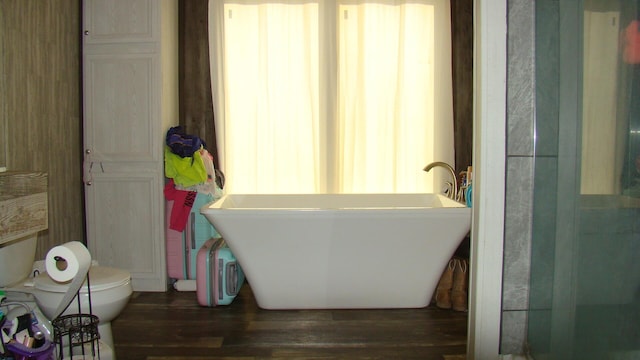 bathroom featuring hardwood / wood-style floors, sink, a tub, and toilet