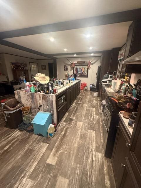 kitchen featuring electric range, dark brown cabinetry, and light hardwood / wood-style flooring