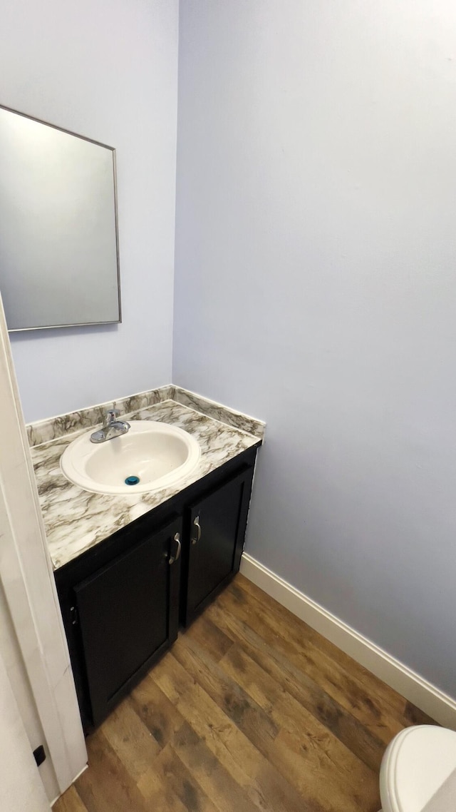 bathroom featuring hardwood / wood-style floors, vanity, and toilet