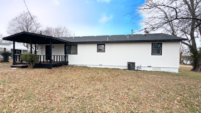 back of property with covered porch, cooling unit, and a lawn