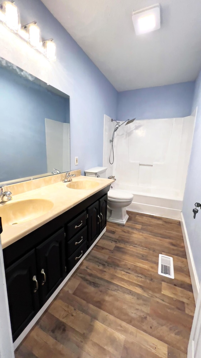 full bathroom with shower / bathing tub combination, hardwood / wood-style floors, vanity, and toilet