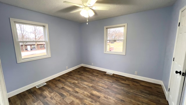 spare room with dark hardwood / wood-style floors, ceiling fan, and a textured ceiling