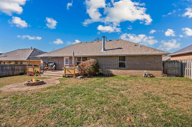 back of house featuring a lawn and a wooden deck