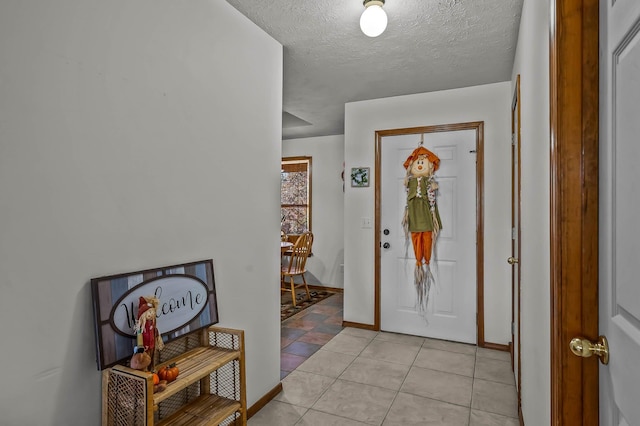 tiled entryway featuring a textured ceiling