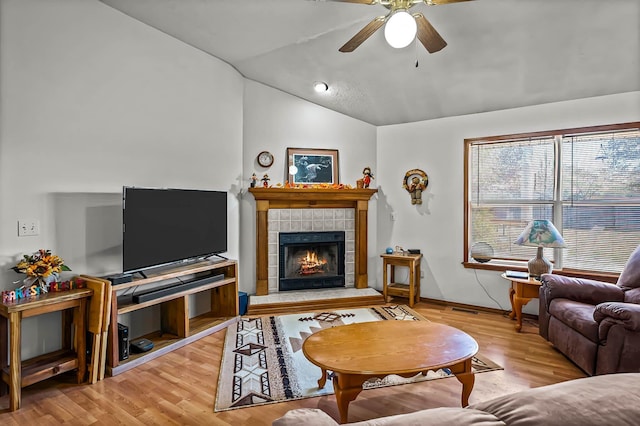 living room featuring a tiled fireplace, ceiling fan, lofted ceiling, and hardwood / wood-style flooring